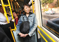 戴著耳機背著包包的「準第一夫人」周美青25日上午依舊搭乘606公車上班，低調少話的周美青面帶微笑望著窗外街景。