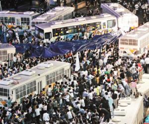大批南韓民眾二日在首爾市區示威，包圍警方部署的巴士，抗議政府準備再度進口美國牛肉。(美聯社)