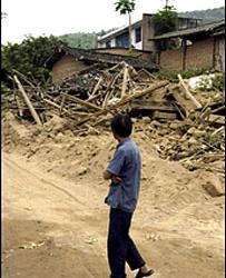 攀枝花市大龍潭鎮一位村民望著被毀房屋