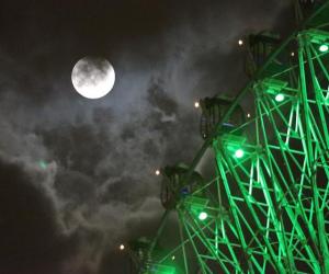 台北市31日晚間雲層較厚，今年7月的2次滿月在雲層中 若隱若現，按目前通俗說法，1個月內的第2次滿月被稱 為「藍月（bluemoon）」。有民眾則搭乘摩天輪賞月